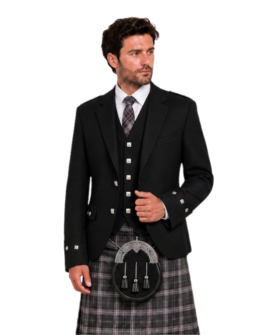 Man wearing a black Argyle Jacket with silver buttons along with grey and brown plaid kilt against white background.