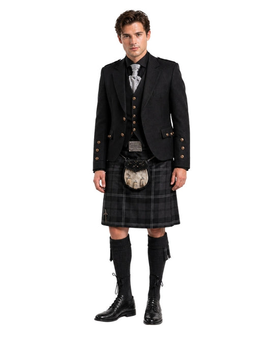 Man wearing a traditional Scottish kilt with jacket and boots on a white background