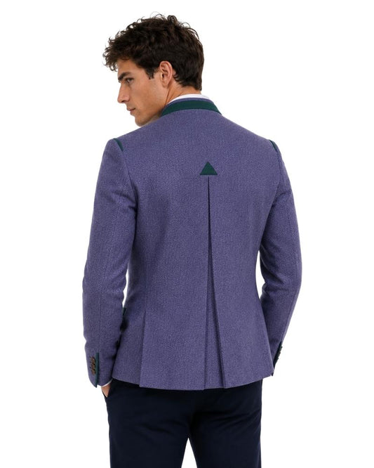 Man wearing a purple blazer with a green lapel on a white background