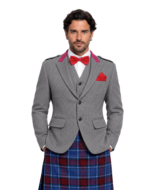 Man wearing a gray blazer, red bow tie, and blue plaid kilt on a white background