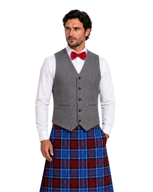 Man wearing a gray vest, white shirt, red bow tie, and blue plaid kilt on a white background