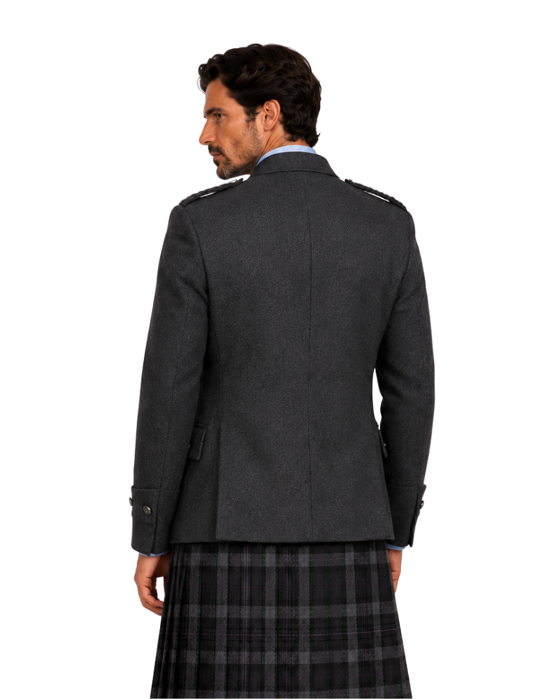 Man wearing black argyle jacket with grey and black plaid kilt on a white background.