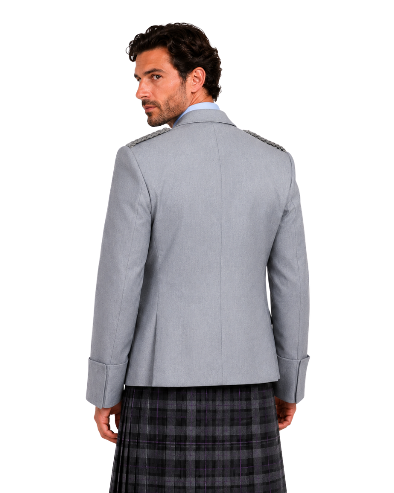 A man shown from the back wearing a light gray blazer with shoulder epaulets and a dark gray and black plaid kilt, against a plain white background.