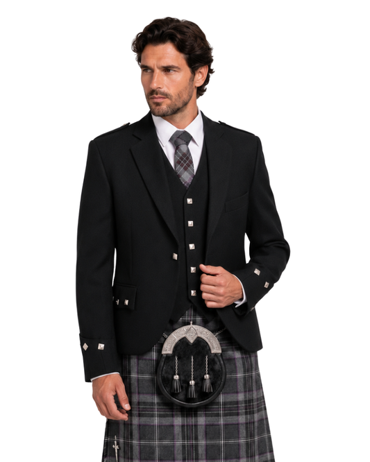 Man wearing a black Argyle Jacket with silver buttons along with grey and brown plaid kilt against white background.