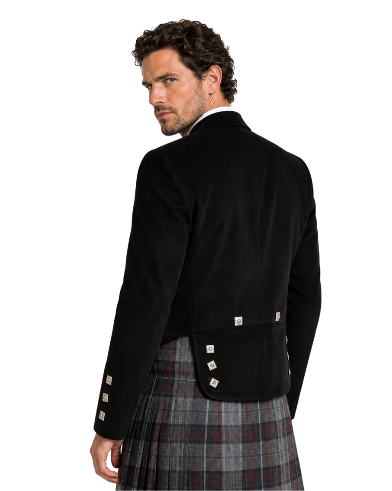 Man wearing a black jacket and plaid kilt on a white background