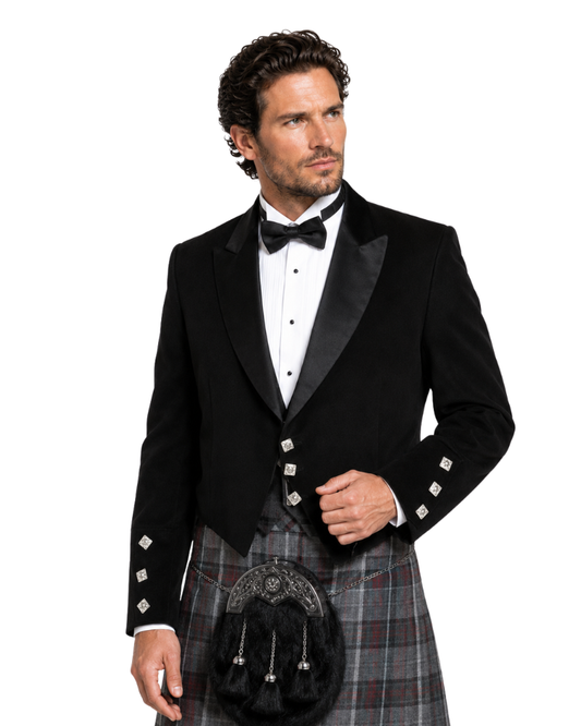 Man wearing a black tuxedo with a kilt on a white background