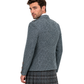 Man wearing a patterned jacket and plaid kilt on a white background