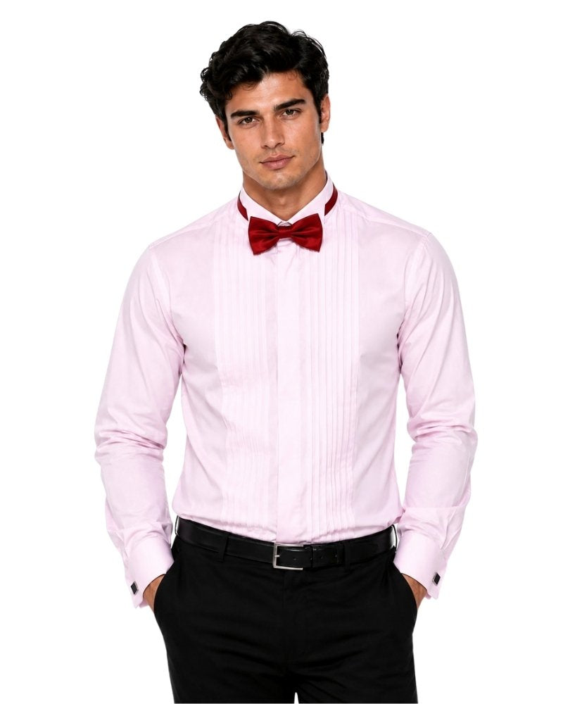 Man wearing a light pink dress shirt with a red bow tie and black pants on a white background