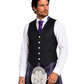 Man wearing a black waistcoat, white shirt, purple tie, and plaid kilt on a white background