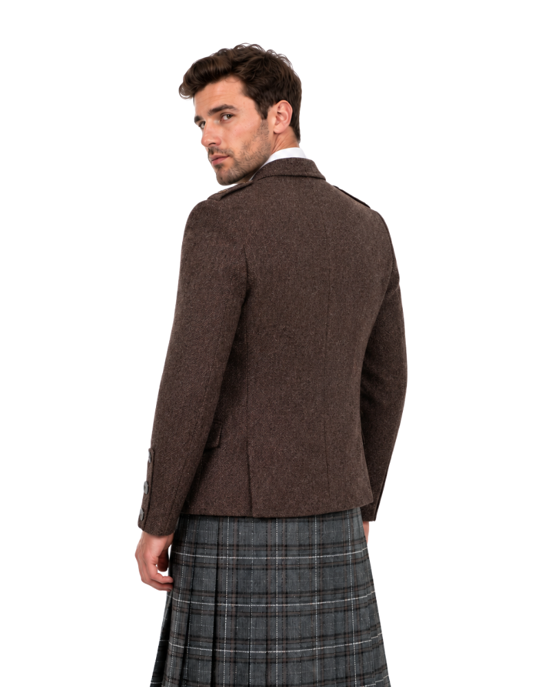 Man wearing a brown jacket and plaid kilt on a white background