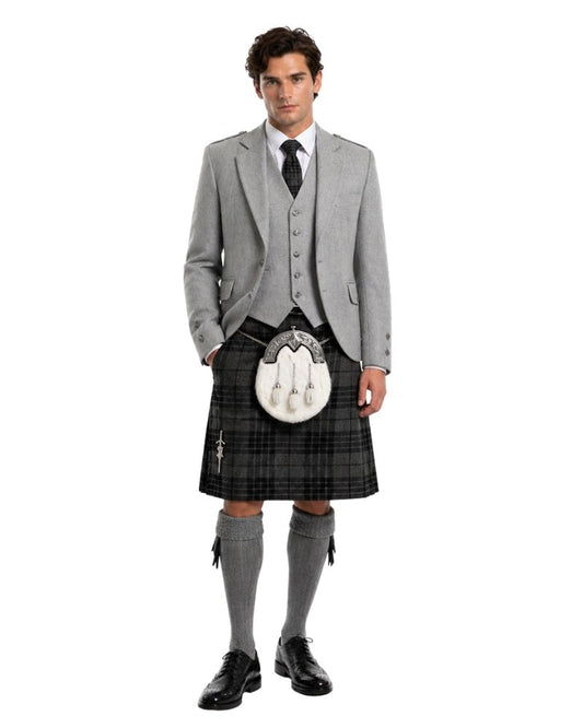 Man wearing a traditional Scottish kilt with a gray jacket and socks on a white background